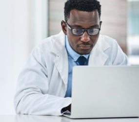 Shot of a young doctor using a laptop at his desk.
